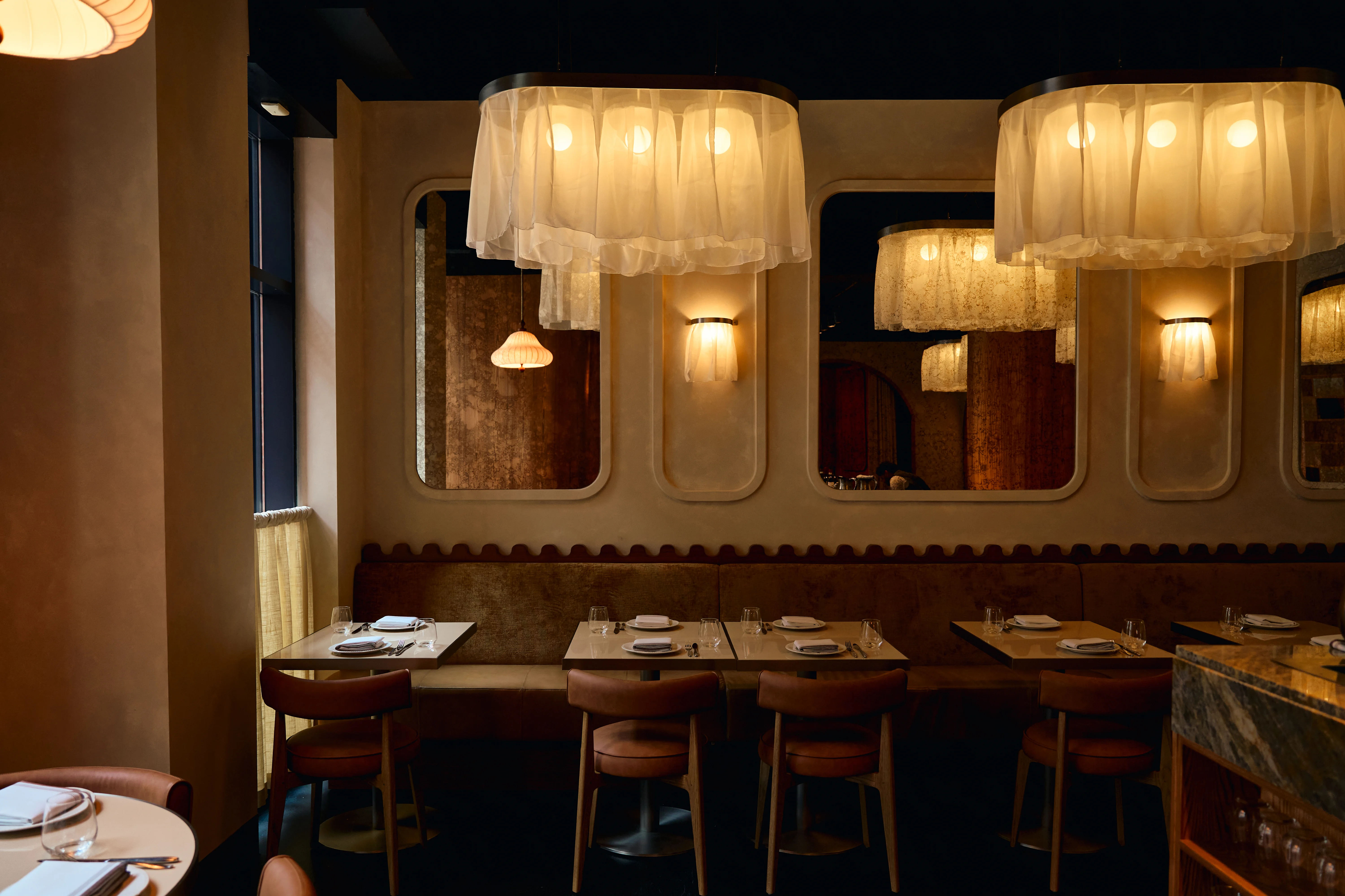 Eloise dining room — warm wood, cascading fixtures, candlelight
